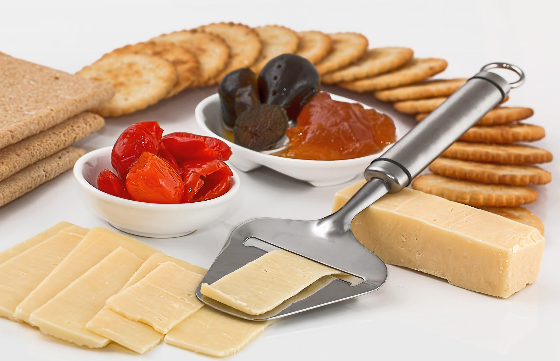 A cheese platter with crackers and dates.