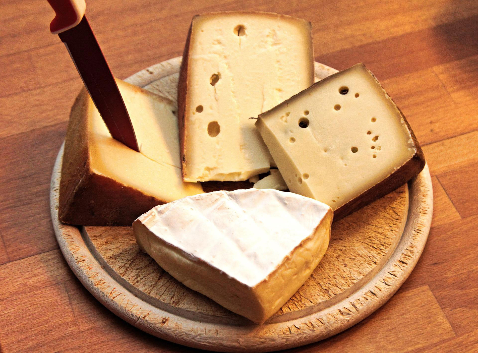 A platter of cheese wedges with a knife.